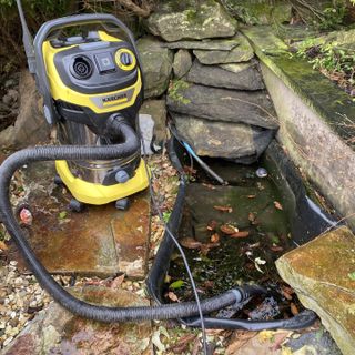 Kärcher WD 6 P Premium Wet and Dry Vacuum Cleaner outside on rocks next to small pond