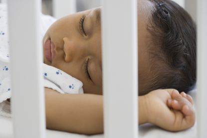 African american baby asleep in a cot