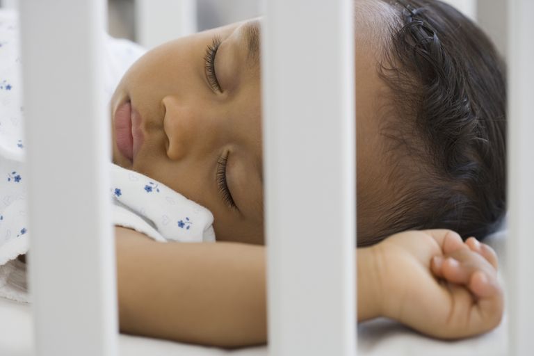 African american baby asleep in a cot