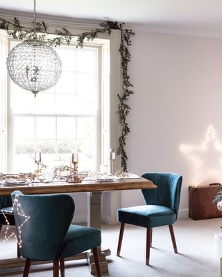 A dining room with garland draped over window sill