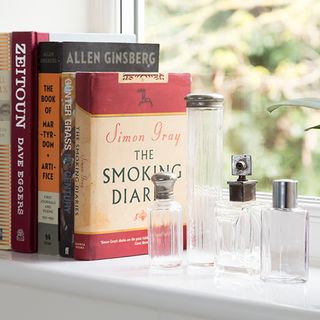 books with window sill and glass tiny bottle
