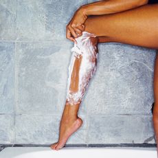 Woman Shaving her legs in the shower