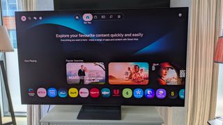 Samsung S90H OLED TV with Tizen home page on screen