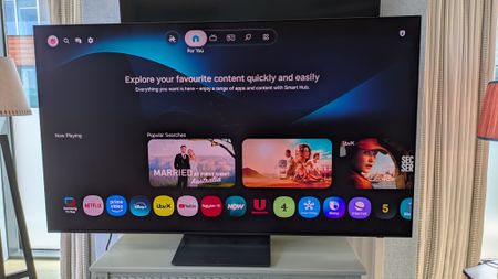 Samsung S90H OLED TV with Tizen home page on screen