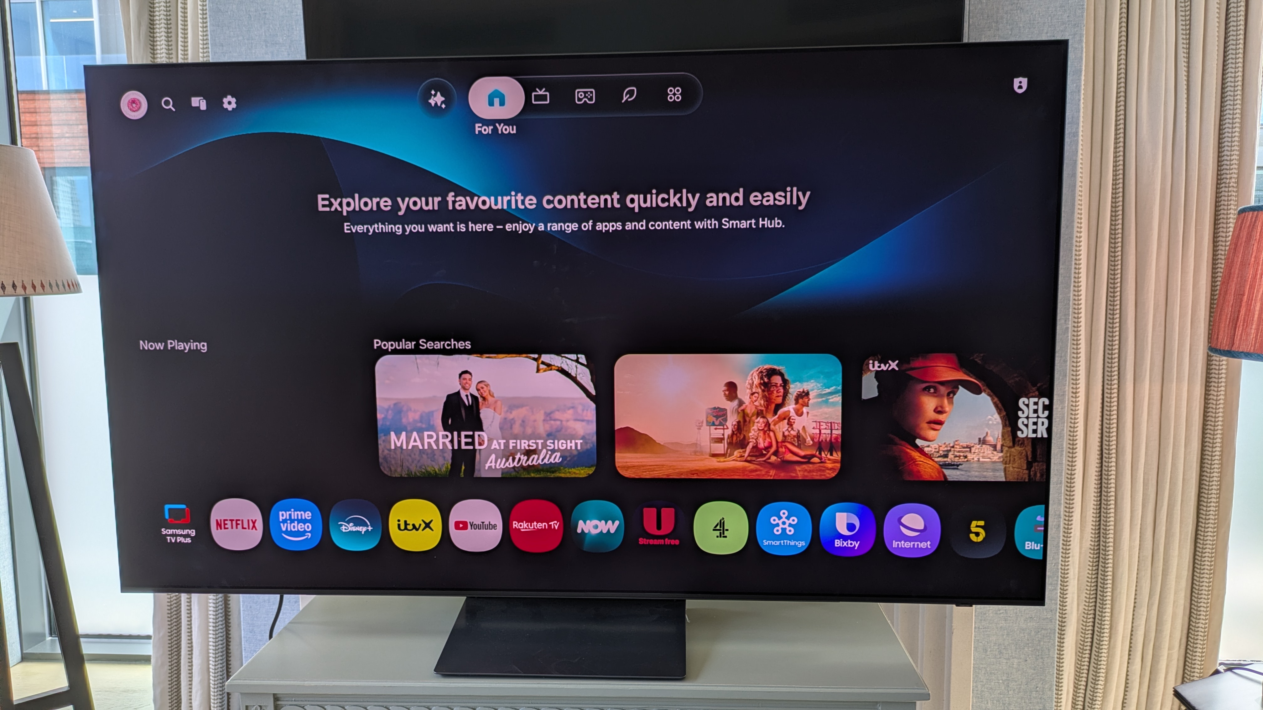 Samsung S90H OLED TV with Tizen home page on screen