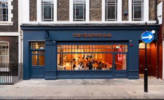Blue exterior of The Seafood Bar showing a glimpse of people dining inside