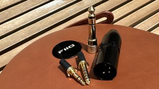 The connectivity options with the FiiO FT3 headphones on a wooden surface