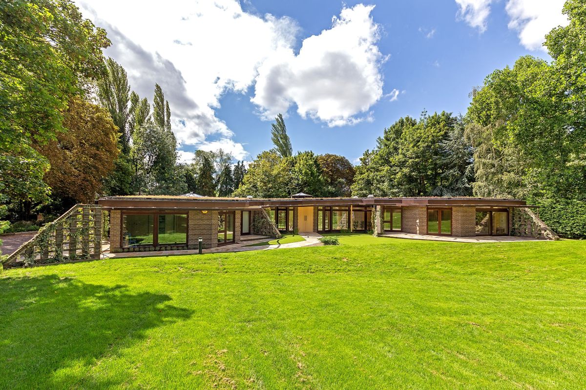 An exterior view of the house with the lawn at the forefront of the image