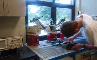 A student modernizes older instructional robots in the MakerSpace.
