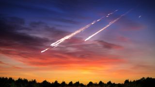 A fireball metero exploding and trailing smoke through the sky during a sunset