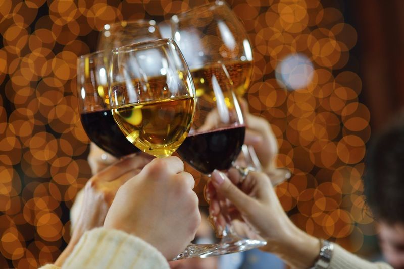 People raise wine glasses to toast