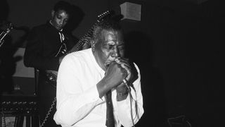CIRCA 1965: Blues singer and harmonica player Howlin' Wolf (born Chester Arthur Burnett, 1910-1976)performs live on stage in Detroit, Michigan circa 1965. Guitarist Hubert Sumlin (1931-2011) plays behind