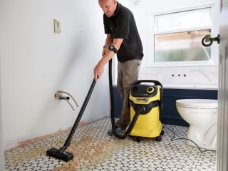 A builder uses a Kärcher WD 5 to vacuum up mess in a newly installed bathroom