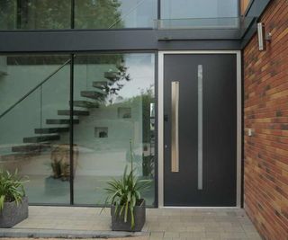 A modern brick and glass home with a large alumiunium front door from Internorm