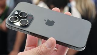 The back of the iPhone 15 Pro Max as it's held in a hand