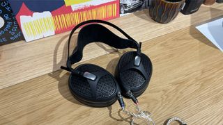 Meze Audio Empyrean II open-back headphones lying flat on wooden table