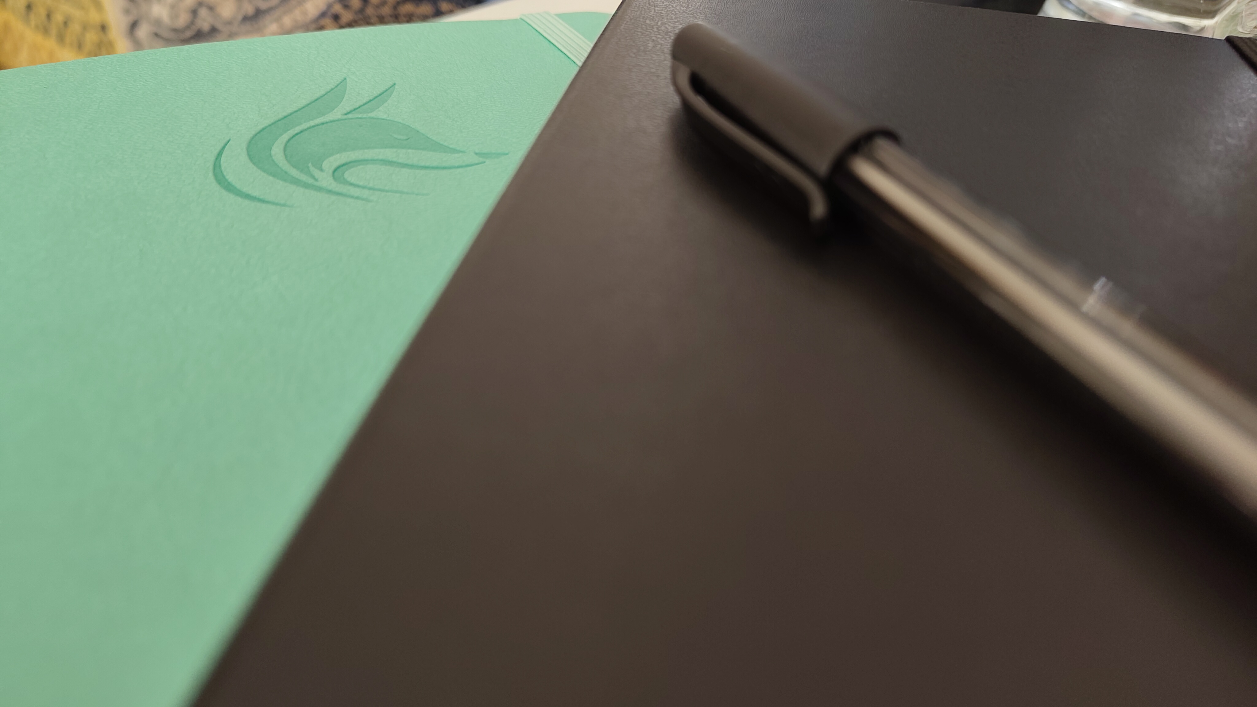 A Clever Fox planner, a Moleskine notebook with a PaperMate pen on top