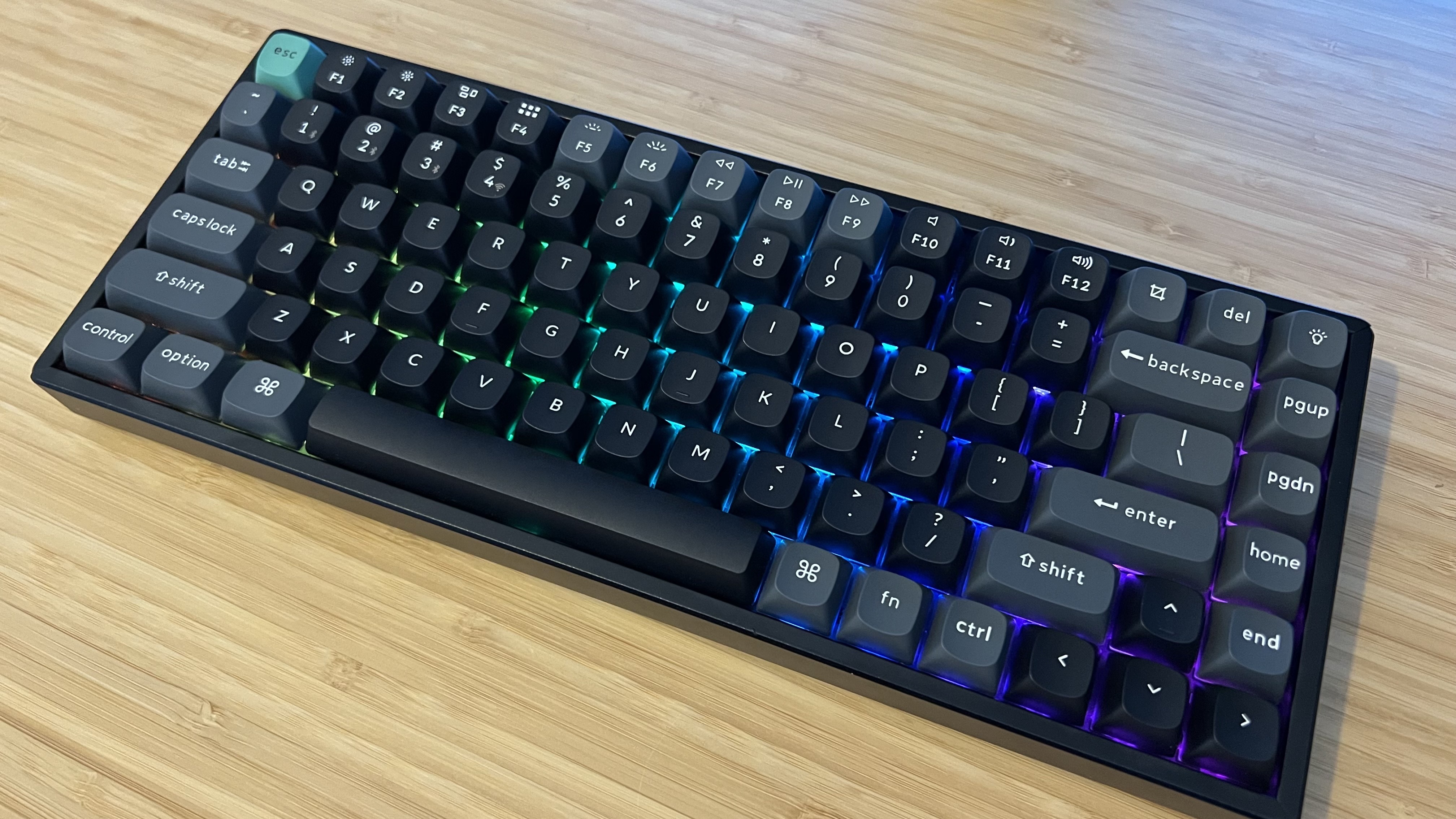 Keychron K2 Ultra 8K gaming keyboard on a wooden desk with RGB lighting on