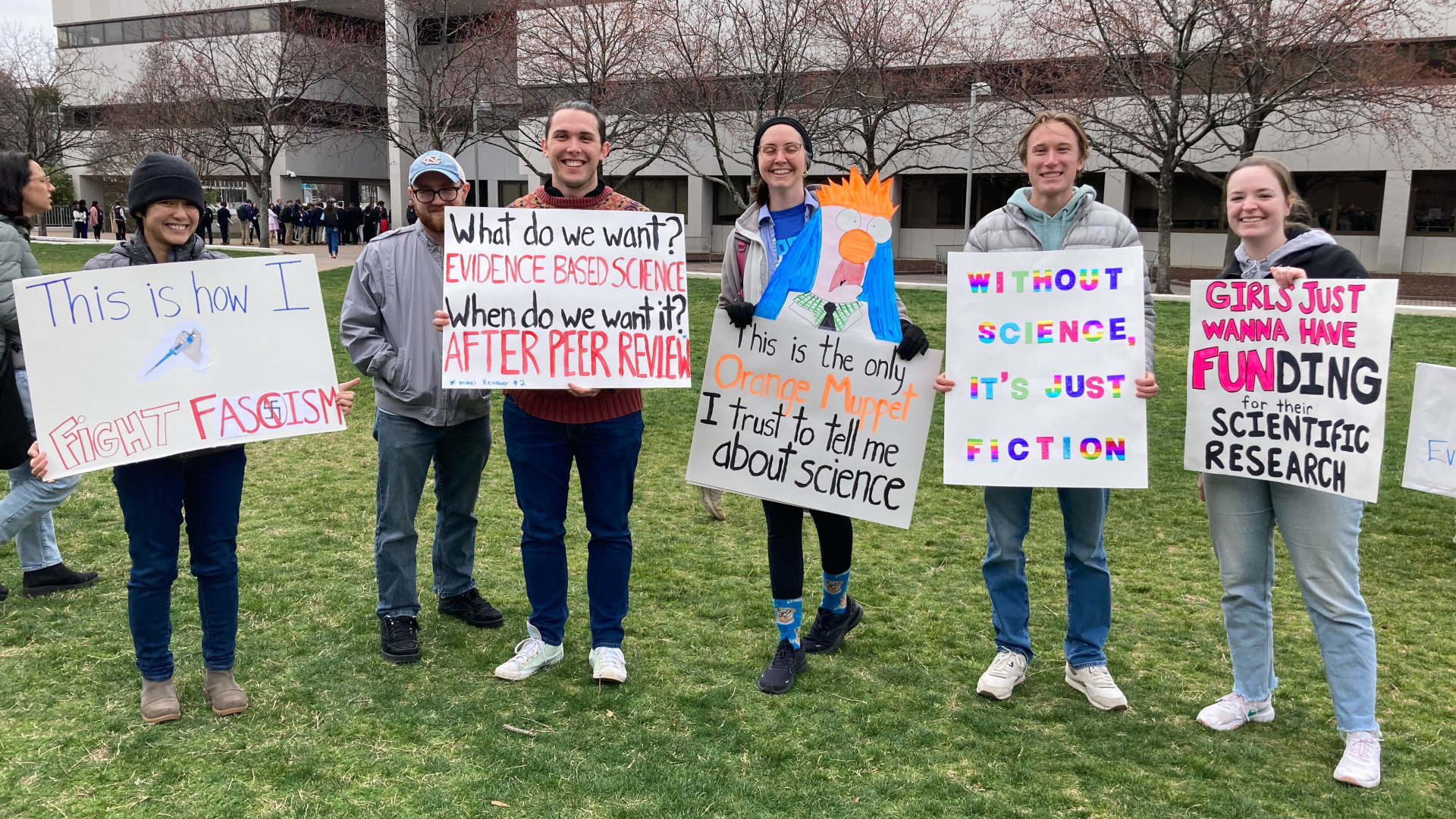 Tembakan poster dan pemrotes di Stand Up For Science Rally di Raleigh; Lima orang memegang tanda pro-sains mereka.