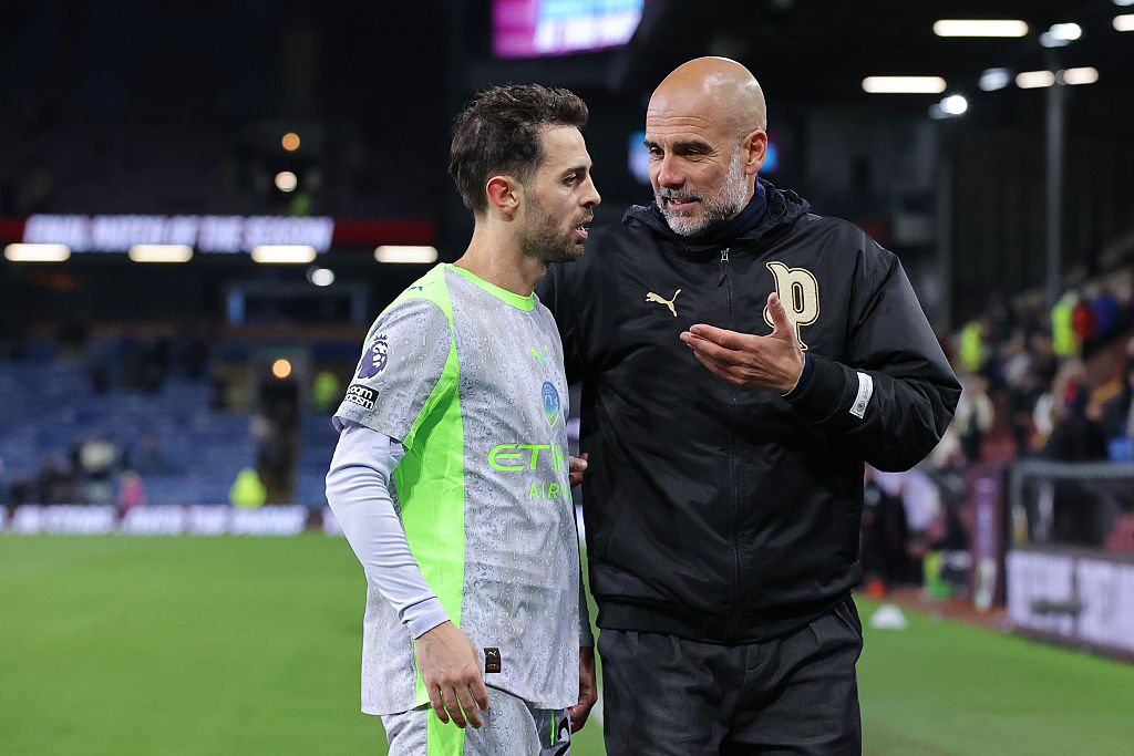 BURNLEY, ENGLAND - APRIL 22: Josep &amp;apos;Pep&amp;apos; Guardiola, head coach of Manchester City, speaks with Bernardo Silva of Manchester City during the Premier League match between Burnley and Manchester City at Turf Moor on April 22, 2026 in Burnley, England. (Photo by James Gill - Danehouse/Getty Images)