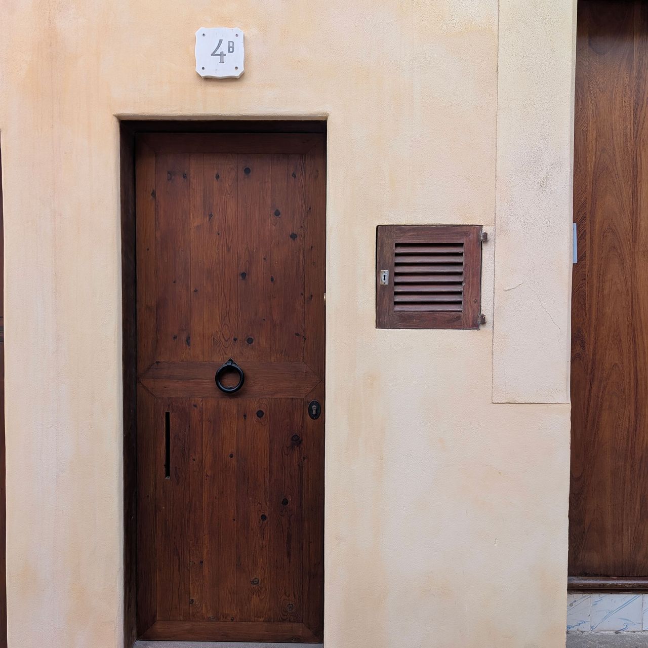 Pale orange/yellow building with wooden front door