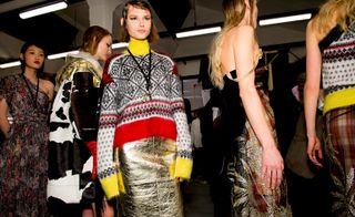 Model wears a bright knit jumper with a metallic skirt, another wears a long gold mesh dress