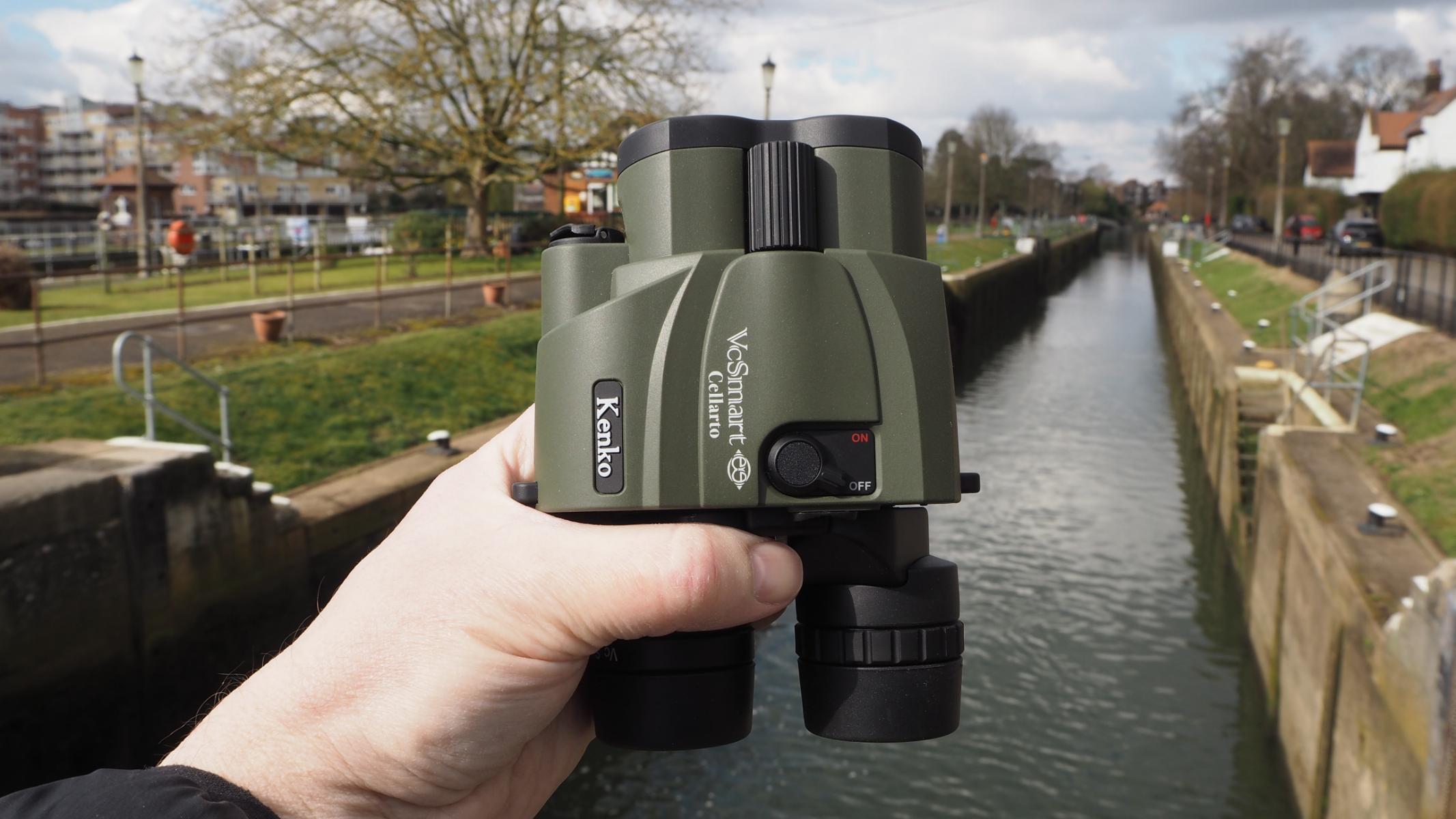 Kenko VC Smart Cellarto 10x30 WP binoculars, held by the author, near a river.