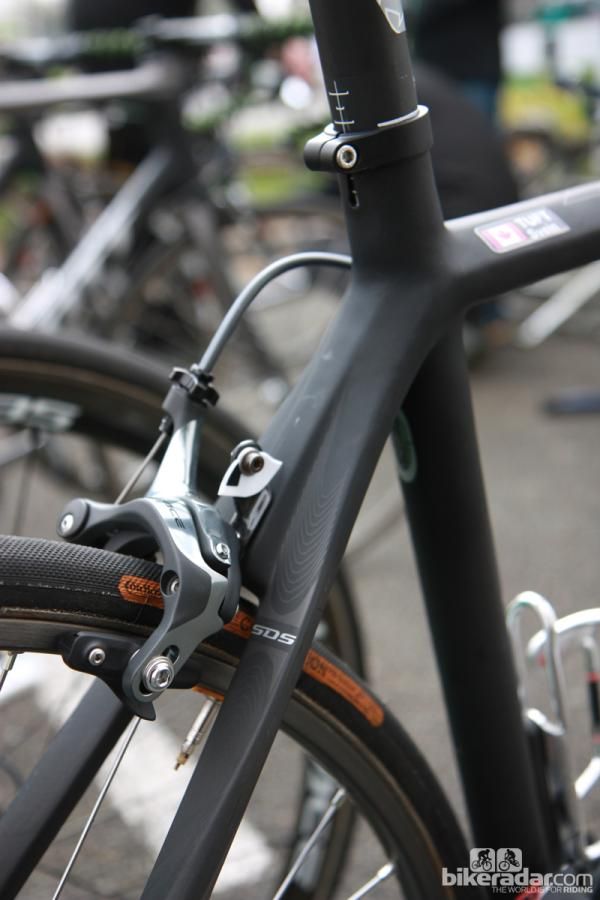 The seat stay wishbone is stoutly built to combat side-to-side flex but the tubes flatten immediately below it. Note the tidy carbon fiber number plate holder bolted behind the brake caliper.