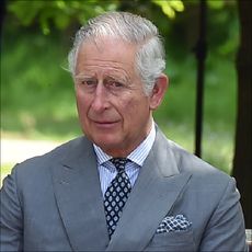 King Charles and Queen Camilla look sad as they sit on a bench at the dedication service for the National Memorial to British Victims of Overseas Terrorism at the National Memorial Arboretum on May 17, 2018