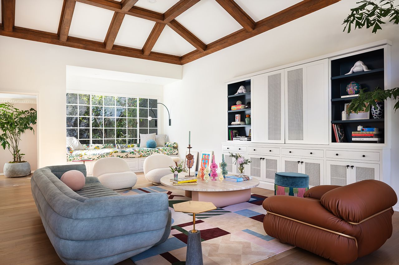 tv room with rounded blue sofa and a window seat