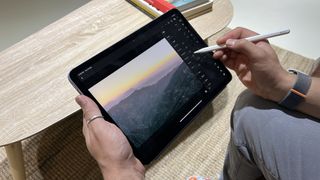 En person som håller i en iPad Air 2022 och redigerar en bild med hjälp av en stylus.