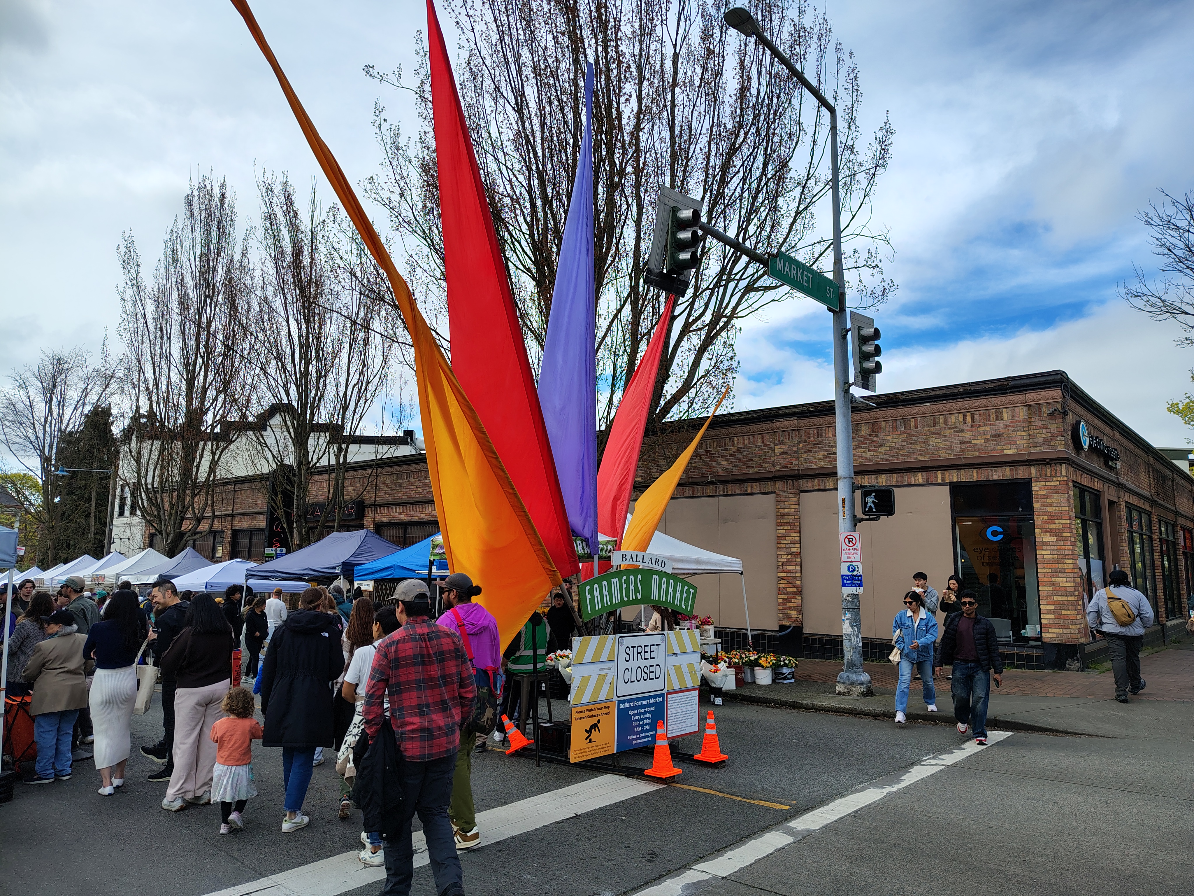 People walking around a sign with colorful flags