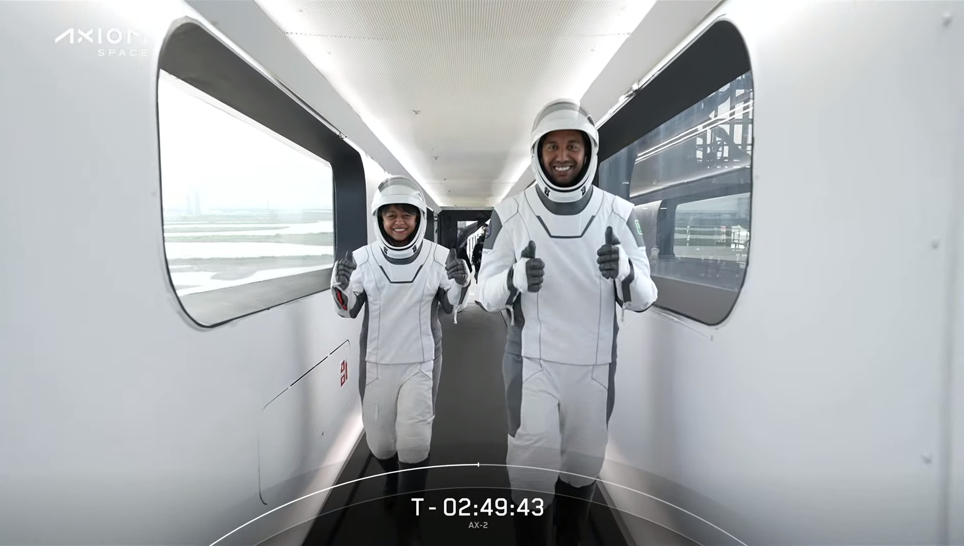 Ax-2 astronauts in spacesuits giving thumbs up on the way to the capsule.