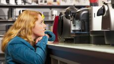 Woman looking at coffee makers on shelf in store