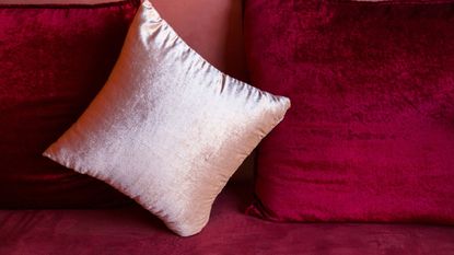 Clean and shiny red and white velvet pillows on a velvet couch - for article on how to wash velvet