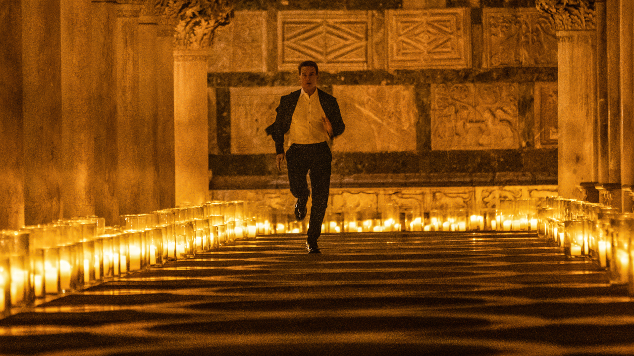 Tom Cruise runs down a candlelit hallway in Mission: Impossible - Dead Reckoning.