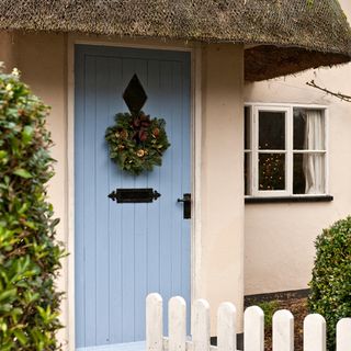 house exterior with blue door and wreath