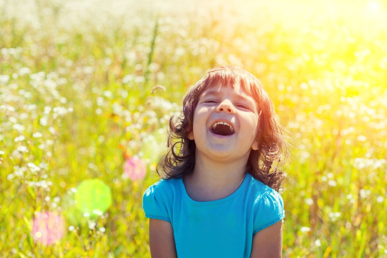 Child Playing In Sunny Meadow