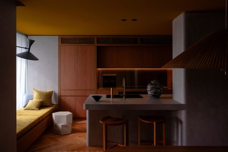Wood kitchen with ochre ceiling by Studio Prineas