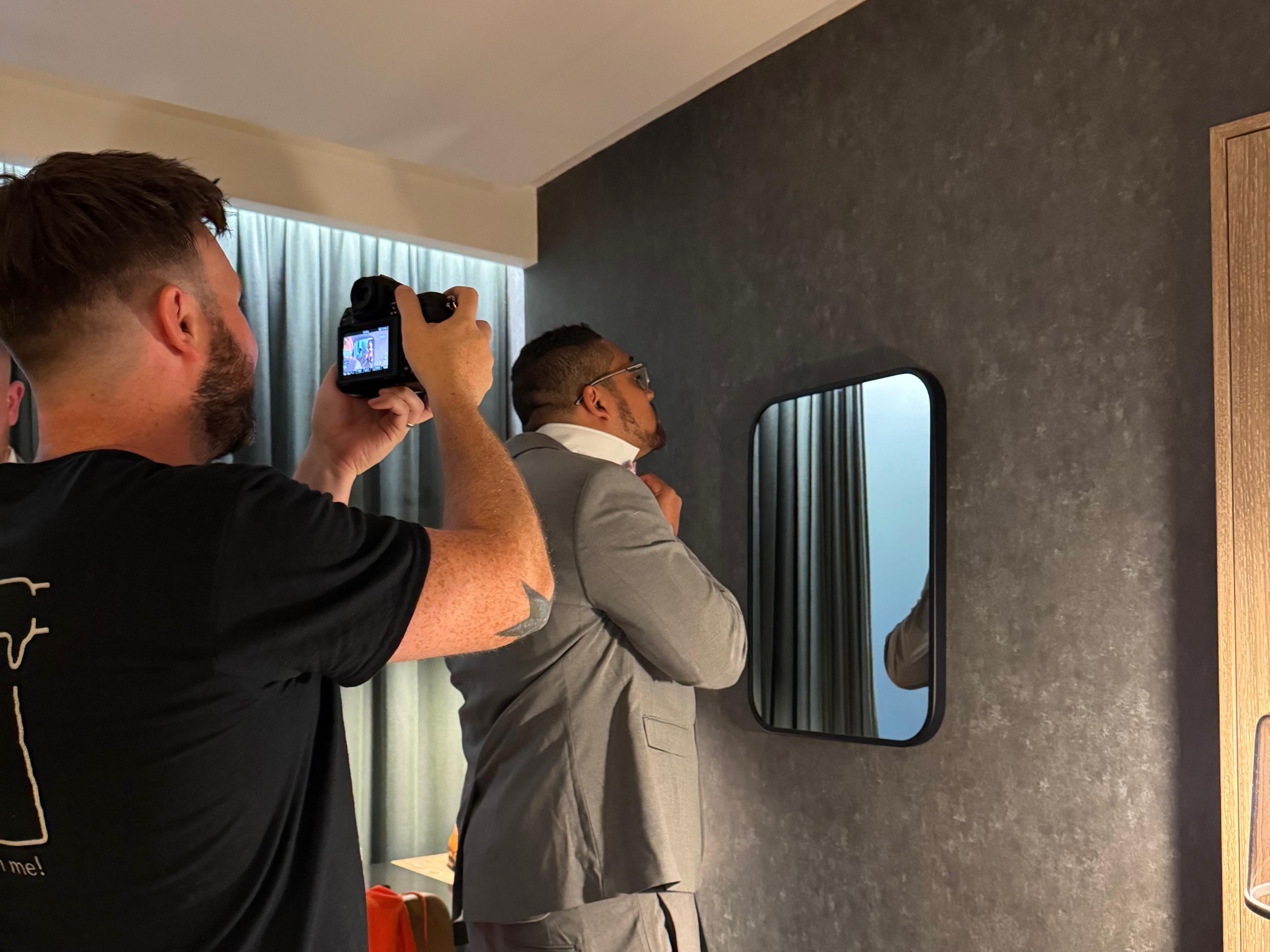 Luke Wybrow (of Eyebrow photography) taking a picture of a groom preparing for a wedding