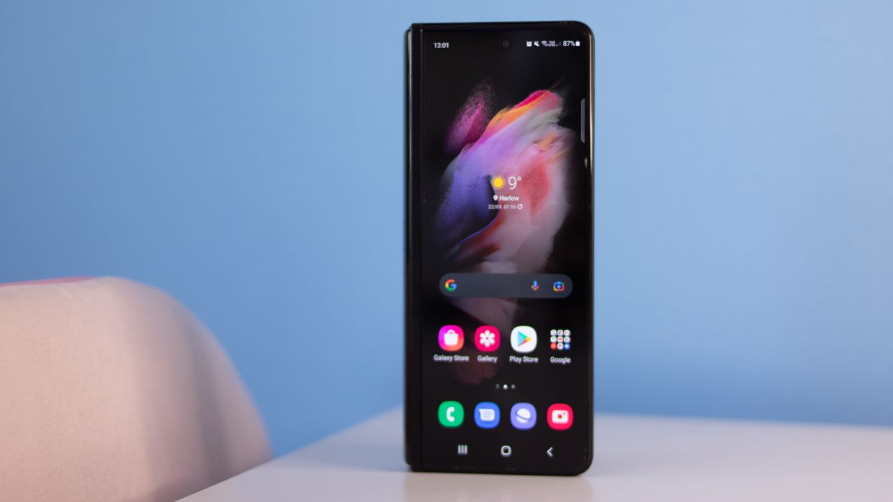 A photograph of the Samsung Galaxy Z Fold 3 folded over and stood on a table