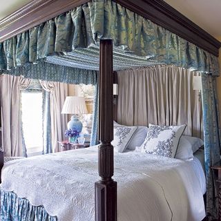 bedroom with canopy bed near lamp