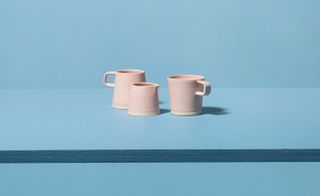 Mugs and pourers in pink grapefruit, by Arran Street East on blur background