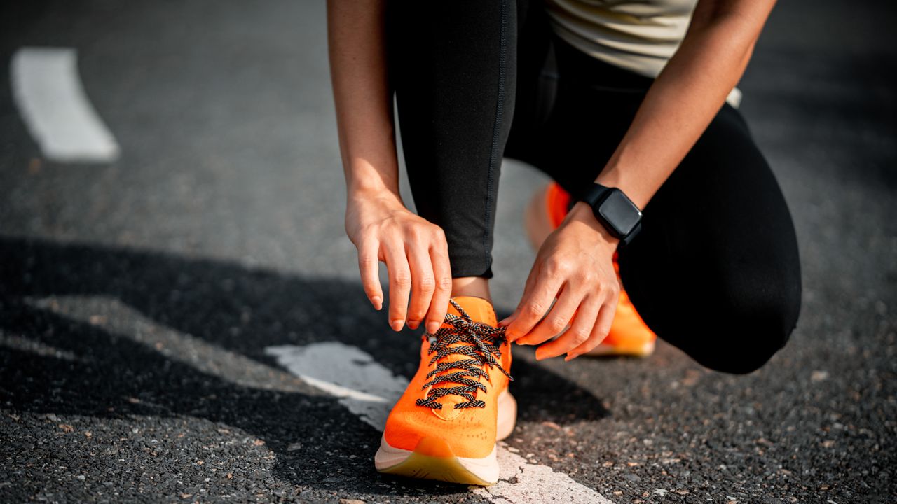 woman tying running shoe laces