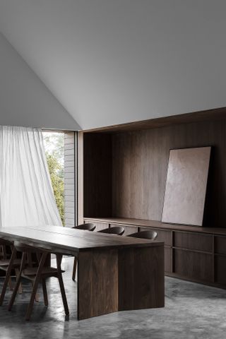 Wood-panelled minimalist dining room with wood dining table