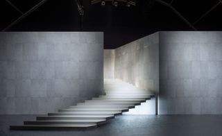 A heavenly white staircase cascaded from a dimly lit, tiled marble entrance from which the models stormed the venue