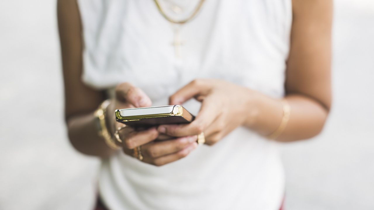 Cropped shot of young woman texting on smartphone