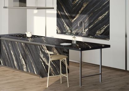 A kitchen with a black marble island and marbled kitchen sink nook