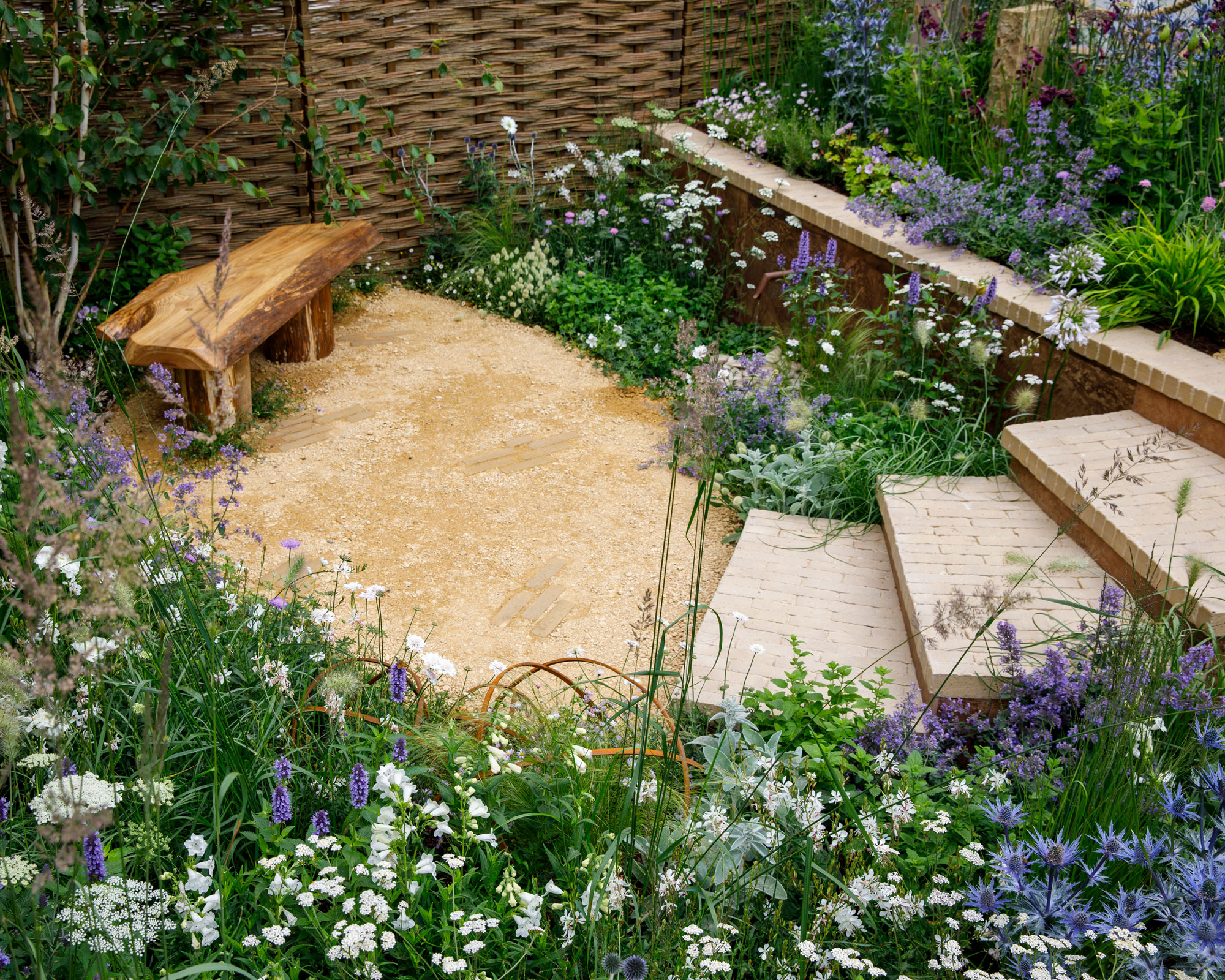 sloping garden design with steps down to secluded seating area