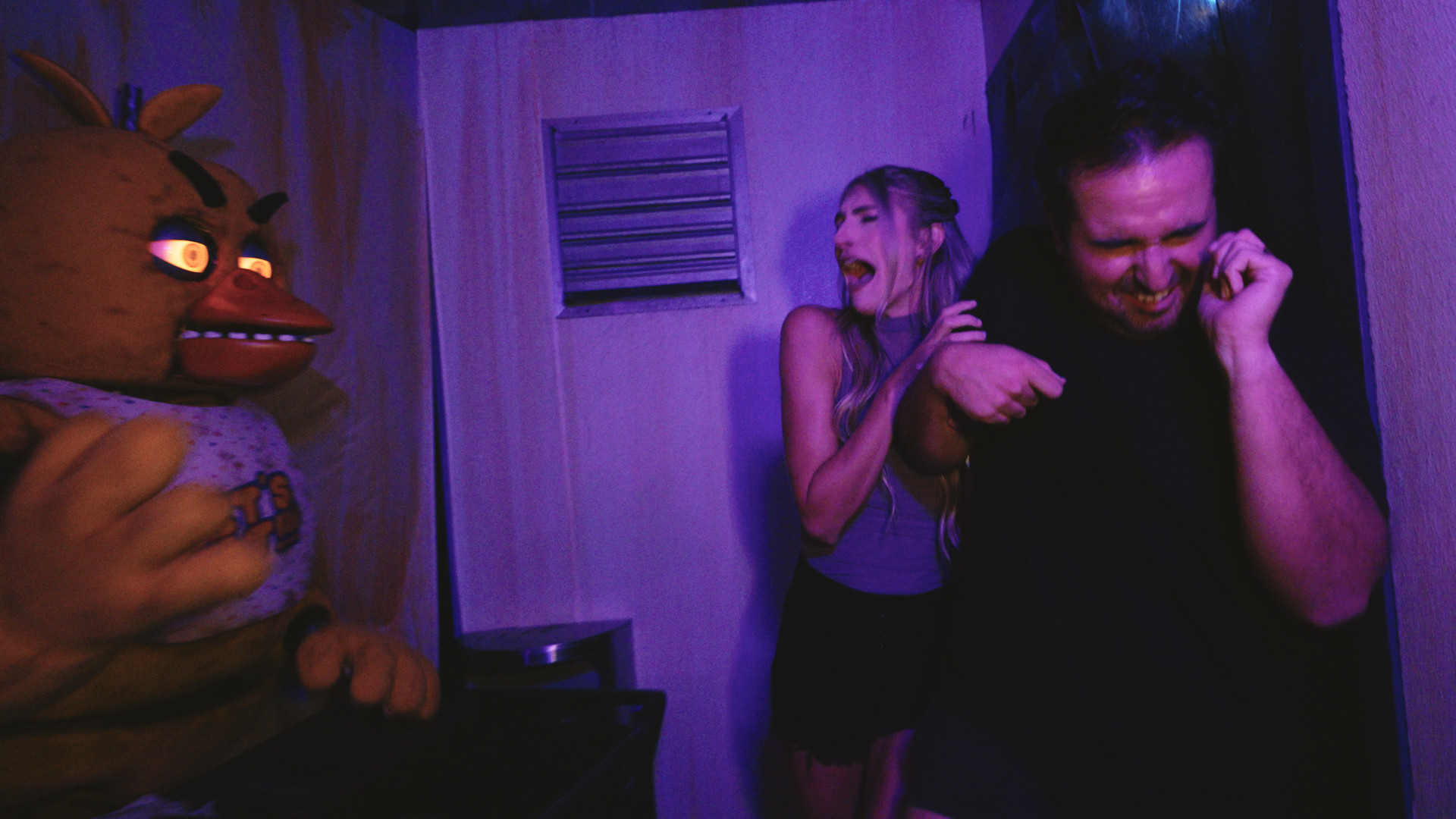 Two people screaming while walking through Universal&#039;s Five Nights at Freddy&#039;s Haunted House